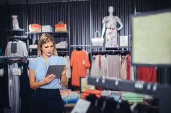 Photo of a young woman using digital tablet in the store.