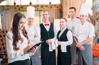 restaurant manager and his staff in kitchen. interacting to head chef in commercial kitchen