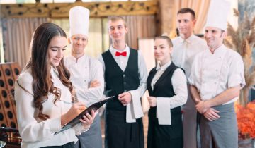 restaurant manager and his staff in kitchen. interacting to head chef in commercial kitchen